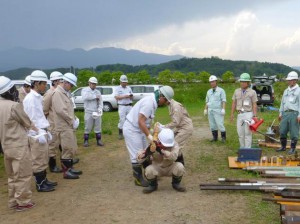 人肩運搬の厳しさ(モンケン運び)を体験する研修生 （福島県立明成高校敷地内）